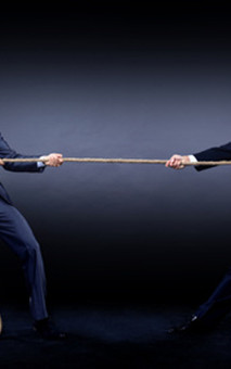 Two business men pulling rope in a competition